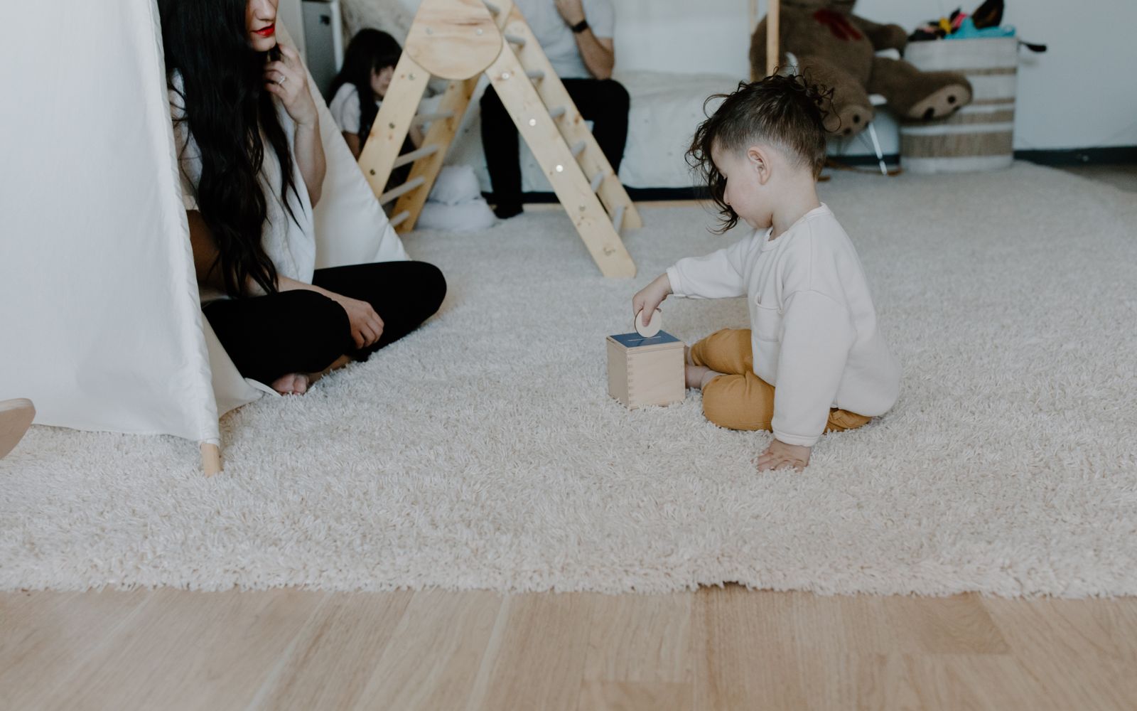 Open play room with low shelves of toys and a soft rug